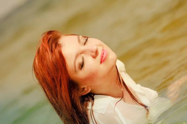 Rossa donna in posa in acqua durante l'estate — Foto Stock