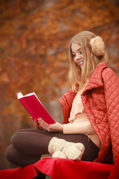 Blond flicka läsebok i hösten landskap — Stockfoto