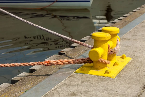 Sailing ropes tied around pins in sunlight — Stock Photo, Image