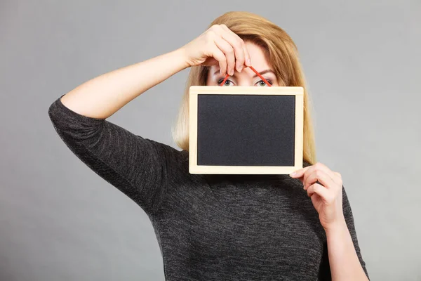 Tartó üres fekete tábla, arcán női — Stock Fotó