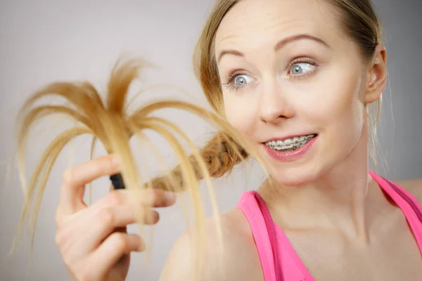 Donna felice guardando le estremità dei capelli — Foto Stock