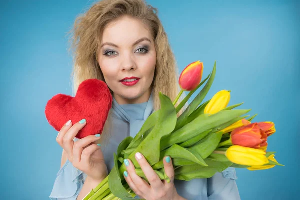 Vrouw houdt tulpen en rood hart — Stockfoto