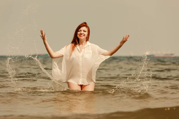 Redhead woman playing in water during summertime — Stock Photo, Image