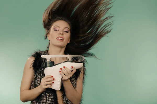 Kvinna med vindpinade hår håller skridsko — Stockfoto