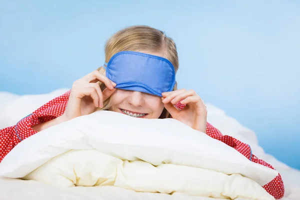 Young woman wearing sleeping eye band in bed — Stock Photo, Image