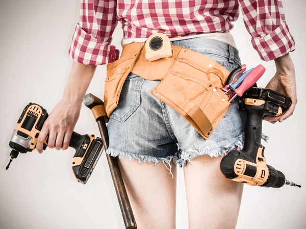 Girl using some power tools for work at home