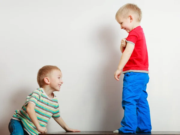 Two little boys siblings playing together on table — Stock Photo, Image