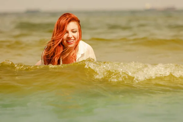 Rotschopf spielt im Sommer im Wasser — Stockfoto