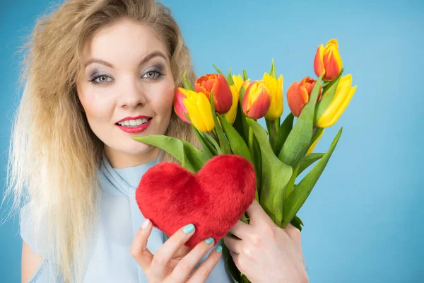 Mulher segura tulipas e coração vermelho — Fotografia de Stock