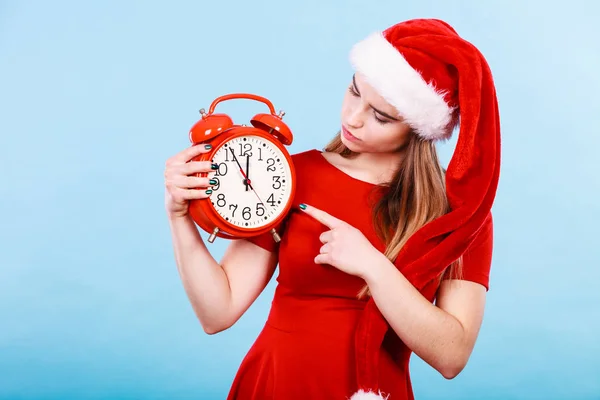 Lycklig kvinna bär Santa Claus kostym holding klocka — Stockfoto