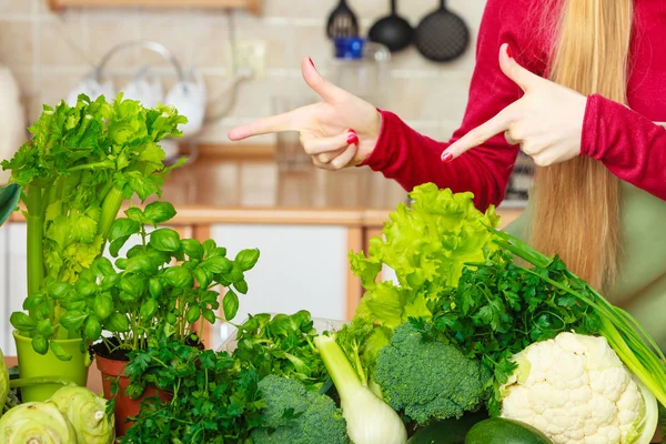 Mulher na cozinha com muitos vegetais verdes — Fotografia de Stock