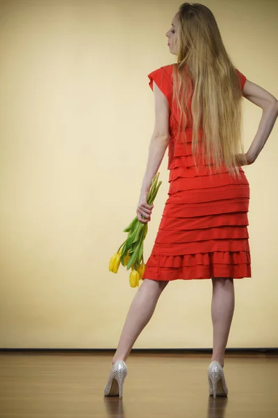 Kvinna med gula tulpaner gäng, bakifrån — Stockfoto