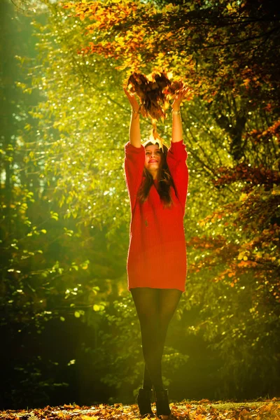 Glad tjej att ha kul med bladen i höstlig park. — Stockfoto