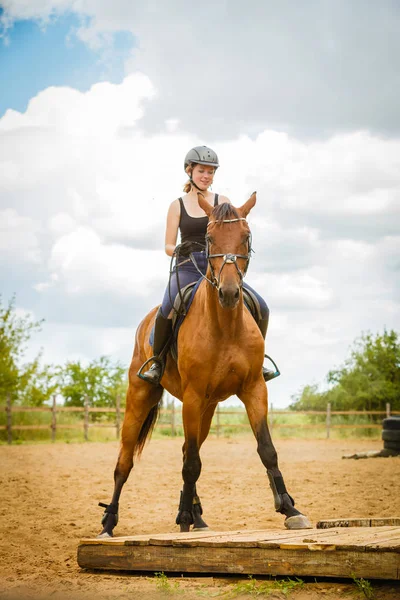 Jockey girl gör häst ridning på landsbygden äng — Stockfoto