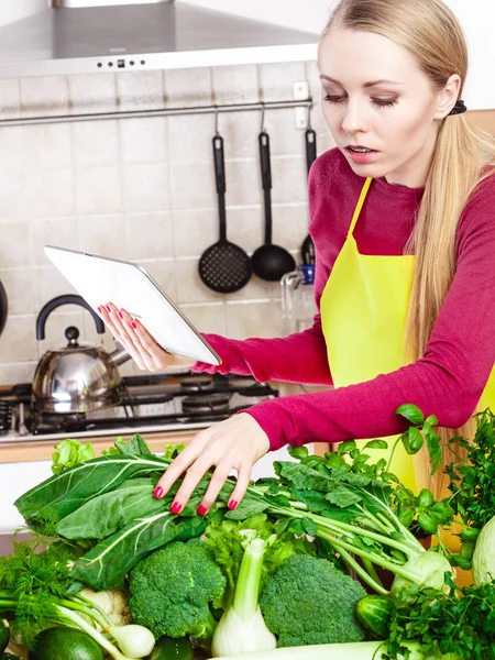 Женщина с зелеными овощами думает о кулинарии — стоковое фото