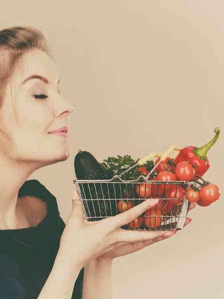 Žena má nákupní košík se zeleninou, vonící — Stock fotografie