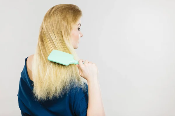 Femme brossant ses cheveux longs avec une brosse — Photo