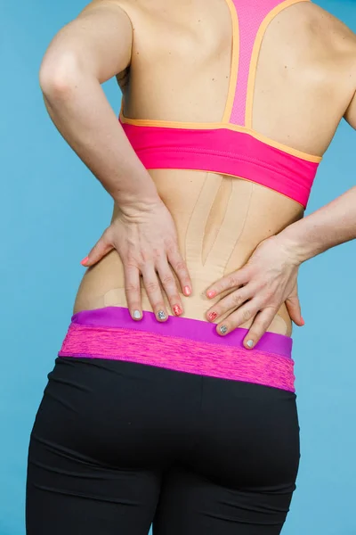 Mujer con kinesio médico grabando en la espalda —  Fotos de Stock