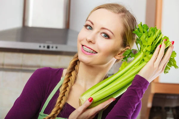 在厨房里的女人抱着绿色的芹菜 — 图库照片