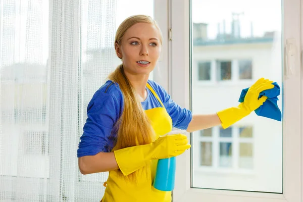 Janela de limpeza da menina em casa usando pano detergente — Fotografia de Stock