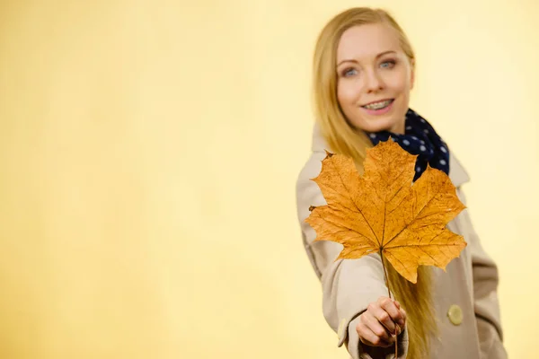 Woman holding orange autumn leaf — Stock Photo, Image