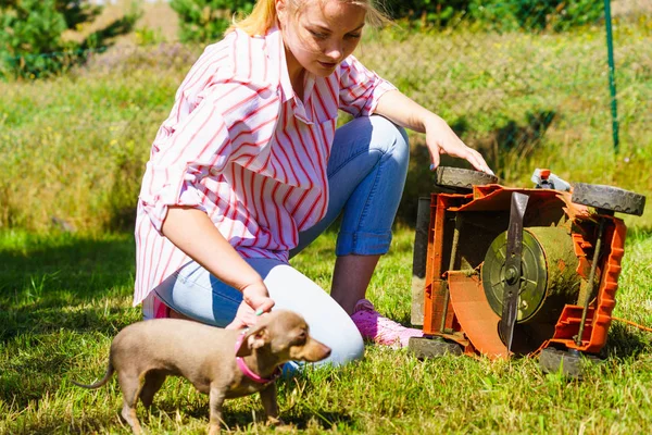 Kvinnlig trädgårdsmästare med trasig gräsklippare — Stockfoto