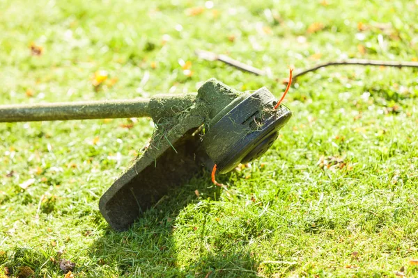 Mower brushcutter on green grass — Stock Photo, Image