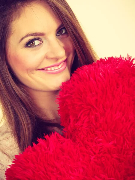 Mujer feliz sosteniendo almohada en forma de corazón —  Fotos de Stock