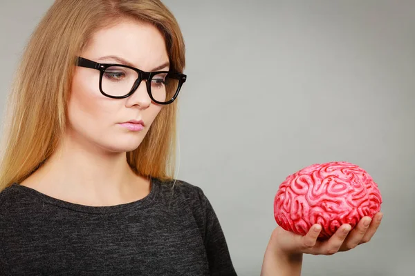 Mujer pensando y sosteniendo cerebro falso — Foto de Stock