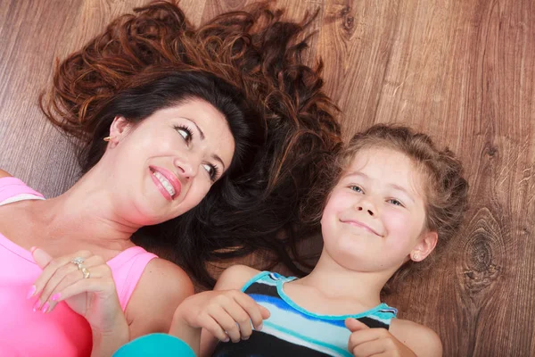 Família feliz. Mãe e filho deitados no chão de casa . — Fotografia de Stock