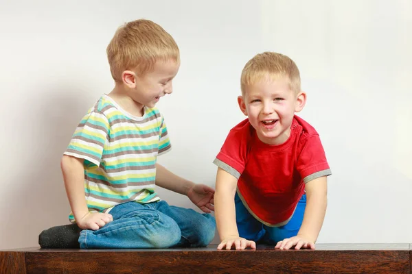 Dos hermanos pequeños jugando juntos en la mesa — Foto de Stock