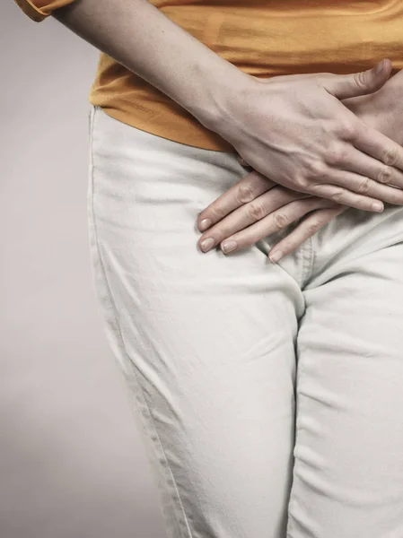 Vrouw met handen met haar kruis — Stockfoto