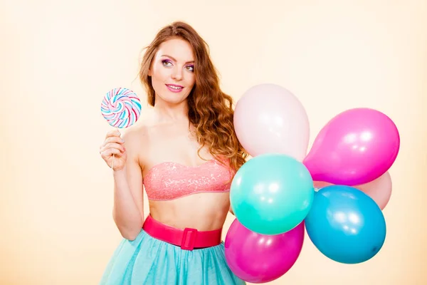 Γυναίκα κατέχει lollipop candy και μπαλόνια — Φωτογραφία Αρχείου