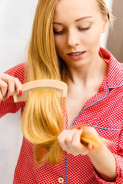 Mulher penteando seu cabelo comprido no banheiro — Fotografia de Stock