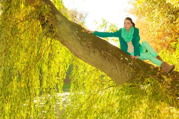 Mujer sentada en tronco de árbol grande — Foto de Stock