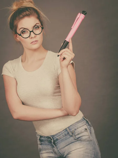 Mujer sosteniendo un gran lápiz de gran tamaño pensando en algo — Foto de Stock