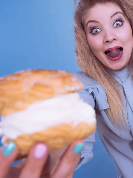 Mujer divertida sostiene pastel de crema de hojaldre —  Fotos de Stock