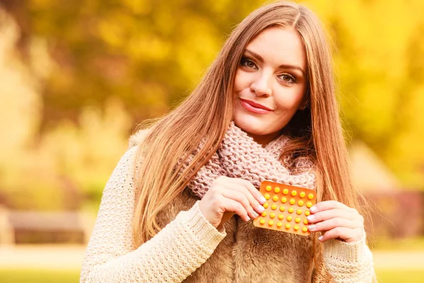 ビタミン薬を保持している秋の公園で女性 — ストック写真