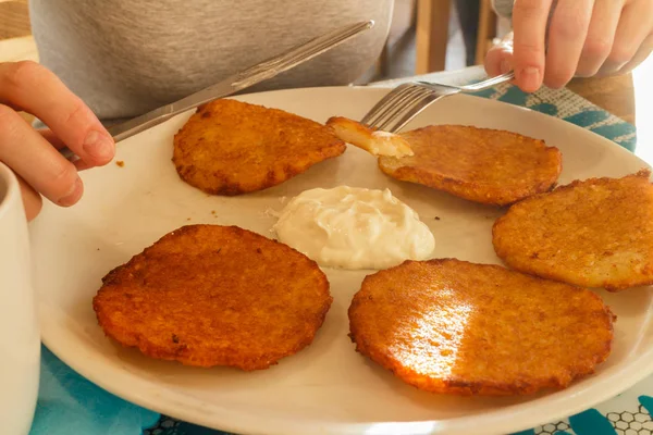 Leckere Kartoffelpuffer auf Teller mit saurer Sahne — Stockfoto