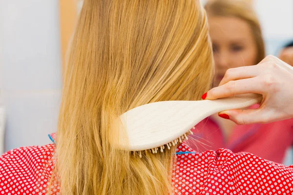 Kvinna borsta hennes långa hår i badrum — Stockfoto