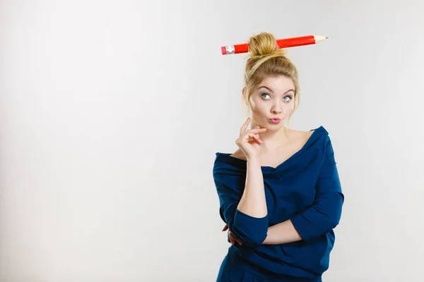 Myšlení blondýnka s velká tužka v vlasy — Stock fotografie