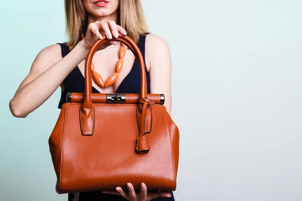 Женщина держит коричневую кожаную сумку. — стоковое фото