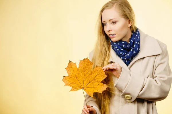 Woman holding orange autumn leaf — Stock Photo, Image