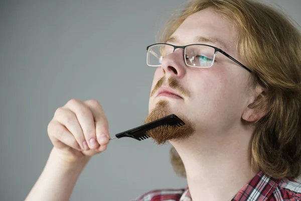 Homem penteando sua barba — Fotografia de Stock