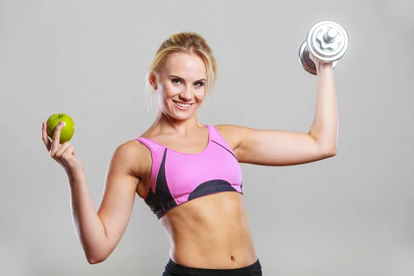 Diet fit body. Girl holds dumbbells and apple fruit — Stock Photo, Image