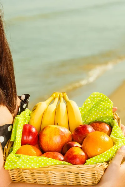 Mulher segurando cesta de piquenique com frutas — Fotografia de Stock