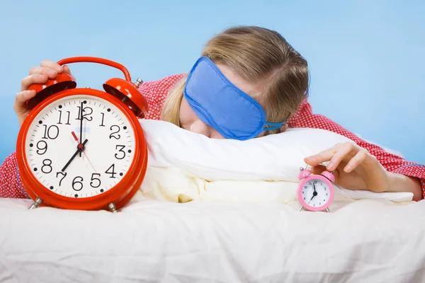 Mujer dormida usando pijamas sosteniendo reloj —  Fotos de Stock