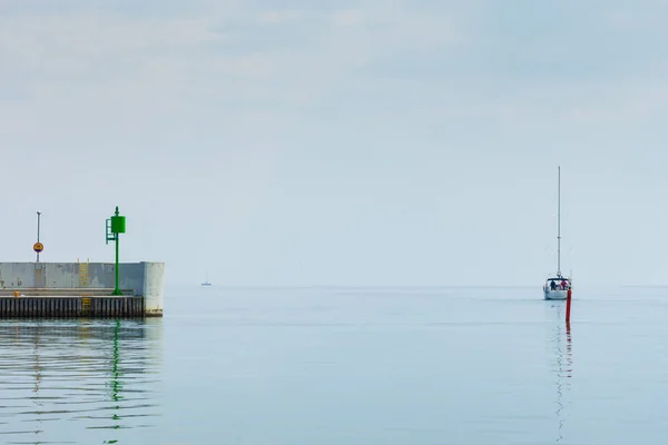 Маленькая яхта плывет в гавань — стоковое фото