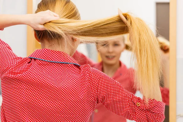 Kvinnan kamma hennes långa hår i badrum — Stockfoto