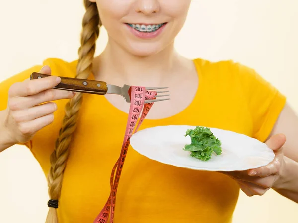 Woman on diet holding plate with lettuce — Stock Photo, Image